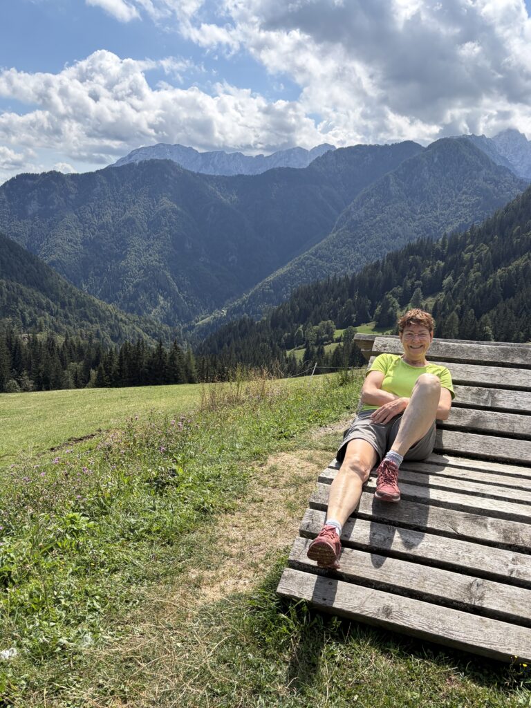 Antje macht Pause auf einer Bank mit Blick auf die Steiner Alpen